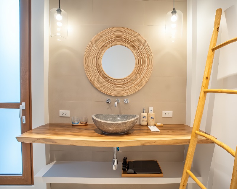 Ensuite bathroom with stone vessel basin and round rattan mirror