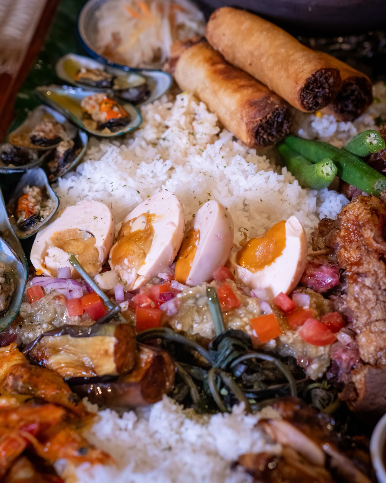 Grilled seafood, rice, and fresh fruit on a banana-leaf spread